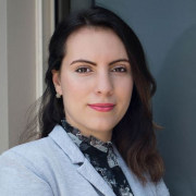 A professional headshot of a woman, smiling at the camera, indicative of a business profile or personal branding image.