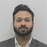 A professional headshot of a person with a confident smile, possibly for a business or personal profile.