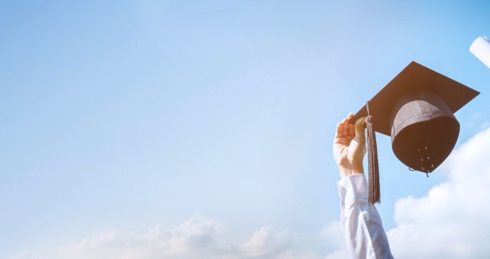 A soft-focused image capturing a person in a flowy white outfit and hat, standing under a clear blue sky, exuding a sense of leisure and freedom.