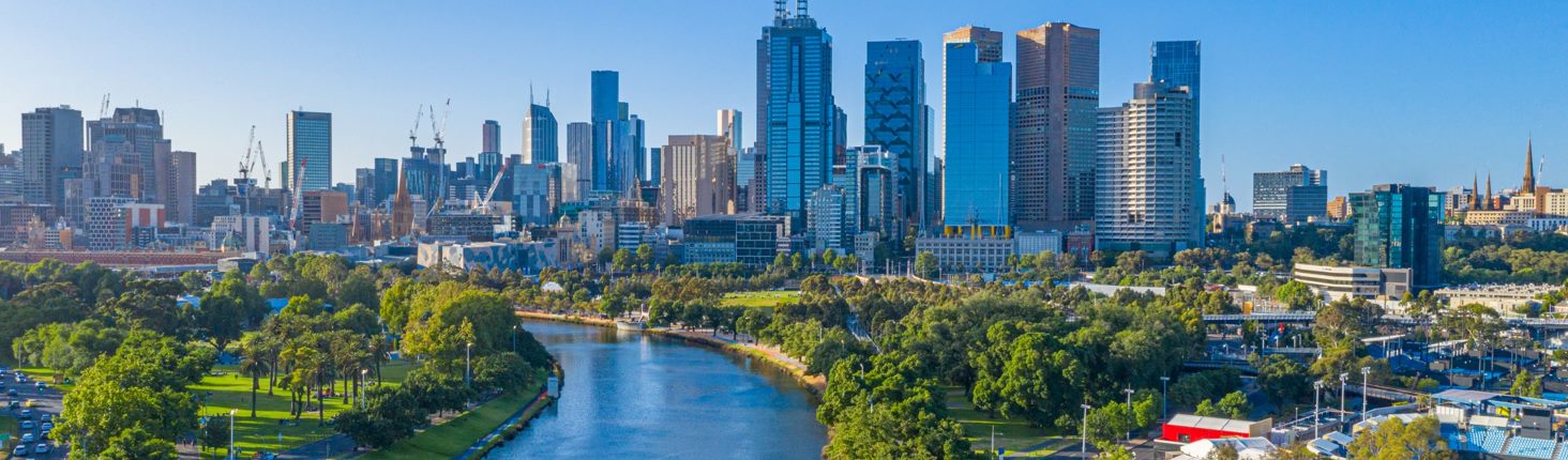 Skyline of a modern cityscape with a river in the foreground, likely representing a destination for migrants or a city where Visa Envoy operates