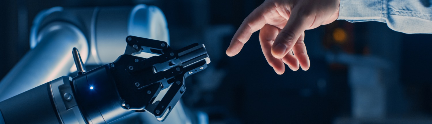 A human hand reaches out towards a robotic arm