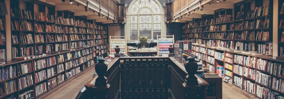 Books line the shelves of a small, well-stocked academic library